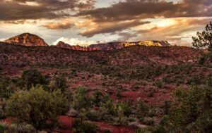 A photograph of the Sedona red rocks under a stormy sunset.