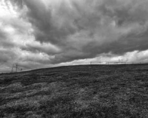 photograph of a dramatic sky under a curved ridgeline