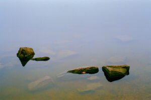 A film photograph of rocks in water