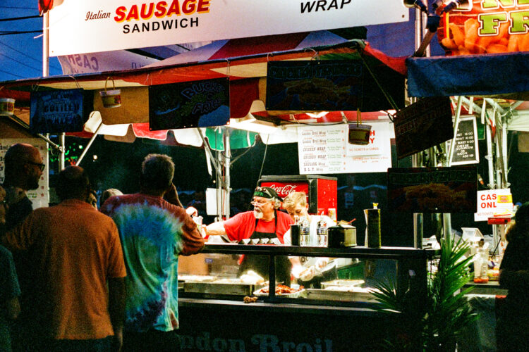 Man servicing sausage sandwiches at Musicfest